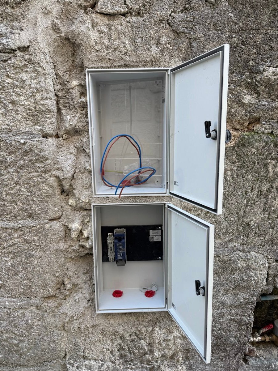 Caixa de contador e portinhola instaladas numa parede de pedra